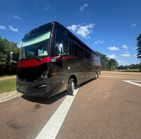 Class A motorhome pulled over on the roadside with a completely shredded tire on the front axle